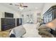 Comfortable main bedroom with stylish furniture, ceiling fan, and doors to the backyard at 19530 Barrie Acres Trl, Odessa, FL 33556
