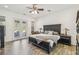 Stylish primary bedroom suite with a large bed, hardwood floors, and access to outdoor space at 19530 Barrie Acres Trl, Odessa, FL 33556