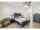 Cozy main bedroom features stylish furniture, wood-look floors and a ceiling fan at 19530 Barrie Acres Trl, Odessa, FL 33556