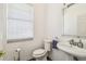 Powder room features a toilet, sink, and large window at 19530 Barrie Acres Trl, Odessa, FL 33556