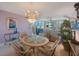Open dining area with glass table, wicker chairs, and a view into the spacious living room with water views at 19701 Gulf Blvd # 231, Indian Shores, FL 33785