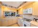 Functional kitchen with cream countertops, microwave, range, and under-cabinet lighting at 19701 Gulf Blvd # 231, Indian Shores, FL 33785