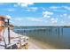 Picturesque waterfront view with a wooden pier, calm waters, and a clear blue sky at 19701 Gulf Blvd # 231, Indian Shores, FL 33785