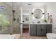 Elegant bathroom featuring a walk-in glass shower and a modern vanity with a round mirror at 20315 Mid Ct, Lutz, FL 33558