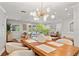 Open concept dining room showcasing a modern chandelier, wood table and ample natural light at 20315 Mid Ct, Lutz, FL 33558