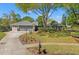 Beautifully landscaped front yard showcasing a well-maintained home with an attached two-car garage at 20315 Mid Ct, Lutz, FL 33558