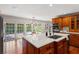 Well-equipped kitchen featuring a large island with sink, wood cabinets, and stainless steel appliances at 20315 Mid Ct, Lutz, FL 33558