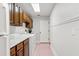 Bright laundry room features white appliances, wood cabinets, pink tile floors, and ample counter space at 20315 Mid Ct, Lutz, FL 33558