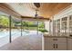 Outdoor kitchen & living space with brick flooring, stone counter and view of pool at 20315 Mid Ct, Lutz, FL 33558