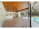 Covered patio with brick flooring, ceiling fans, wet bar, french doors, and view of the pool at 20315 Mid Ct, Lutz, FL 33558