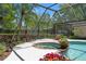 Screened-in pool and spa surrounded by lush landscaping, palm trees, and flowers at 20315 Mid Ct, Lutz, FL 33558