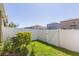 Private backyard with white fence, lush green grass and landscaping at 2126 Golden Falcon Dr, Ruskin, FL 33570