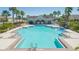 Community pool with clear water, lounge chairs, and lush tropical landscaping at 2126 Golden Falcon Dr, Ruskin, FL 33570