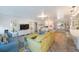 Bright living room featuring multiple sofas and herringbone floors flowing into kitchen area at 22 Oak Ave, Palm Harbor, FL 34684