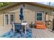 Back deck with dining set, umbrella, a storage bench, and exterior lights offers an inviting outdoor space at 2460 16Th N Ave, St Petersburg, FL 33713