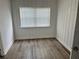 Cozy bedroom with vertical paneling, window with blinds, and durable wood-look flooring at 2460 16Th N Ave, St Petersburg, FL 33713