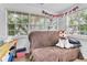 Bright room featuring twin windows, a comfortable futon with a stuffed dog, and cheerful garland decor at 2460 16Th N Ave, St Petersburg, FL 33713