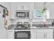 Modern kitchen featuring stainless steel appliances, granite countertops, and white cabinetry at 2460 16Th N Ave, St Petersburg, FL 33713