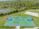 Overhead view of the blue and green basketball court with the volleyball court nearby at 2468 Coco Palm Cir, Wesley Chapel, FL 33543