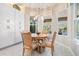 Bright breakfast nook features a round table and chairs by the bright windows at 2468 Coco Palm Cir, Wesley Chapel, FL 33543