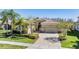 Charming single-story home featuring a well-manicured lawn and an attached two-car garage with a brick-paved driveway at 2468 Coco Palm Cir, Wesley Chapel, FL 33543