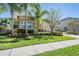 Charming single-story home featuring a well-manicured lawn and an attached two-car garage with a brick-paved driveway at 2468 Coco Palm Cir, Wesley Chapel, FL 33543