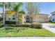 Charming single-story home featuring a well-manicured lawn and an attached two-car garage with a brick-paved driveway at 2468 Coco Palm Cir, Wesley Chapel, FL 33543