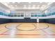 Large gymnasium featuring well-maintained wood floors and basketball hoops perfect for recreation at 2468 Coco Palm Cir, Wesley Chapel, FL 33543