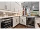 Well-equipped bar area features stainless steel appliances, a wine fridge, and stylish lighting at 2468 Coco Palm Cir, Wesley Chapel, FL 33543
