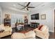 Spacious living room features a large TV, plantation shutters and comfortable upholstered furniture at 2468 Coco Palm Cir, Wesley Chapel, FL 33543