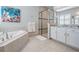 Bright main bathroom featuring white cabinets, granite countertops, and glass enclosed shower at 2468 Coco Palm Cir, Wesley Chapel, FL 33543