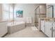 Main bathroom features a soaking tub with tile surround and a glass-enclosed shower at 2468 Coco Palm Cir, Wesley Chapel, FL 33543