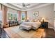 Bright primary bedroom with sitting area, stylish decor, and dark hardwood flooring at 2468 Coco Palm Cir, Wesley Chapel, FL 33543