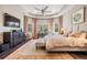 Spacious primary bedroom with tray ceiling, large windows, and a sitting area at 2468 Coco Palm Cir, Wesley Chapel, FL 33543