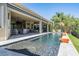 A large pool stretches from the patio and offers a relaxing view of the backyard landscaping, enhancing the outdoor space at 2468 Coco Palm Cir, Wesley Chapel, FL 33543