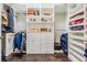 Walk-in closet featuring custom shelving, drawers, and ample storage space at 2468 Coco Palm Cir, Wesley Chapel, FL 33543
