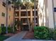 Three story condominium building with balconies surrounded by mature landscaping and palm trees at 2525 W Bay Dr # A11, Belleair Bluffs, FL 33770