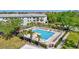 Community pool with palm trees, lounge chairs, and tables with umbrellas at 2700 Bayshore Blvd # 4204, Dunedin, FL 34698