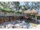 Outdoor tiki hut featuring a cozy outdoor dining area and patio for relaxing, surrounded by landscape and fencing at 275 S Highland Ave, Tarpon Springs, FL 34689