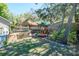 Landscaped backyard with a tiki hut, play structure, and lawn, offering outdoor fun for all at 275 S Highland Ave, Tarpon Springs, FL 34689