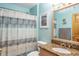 Updated bathroom with decorative shower curtain, granite countertops, and a beautifully framed mirror at 275 S Highland Ave, Tarpon Springs, FL 34689