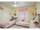 Charming ' bedroom featuring two twin beds, a ceiling fan, and sweet personalized decor at 275 S Highland Ave, Tarpon Springs, FL 34689