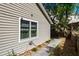The exterior side of the house features neutral siding and landscaping with rocks and greenery at 275 S Highland Ave, Tarpon Springs, FL 34689