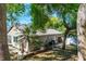 A well-maintained single-story home with mature trees and lush landscaping in a private yard at 275 S Highland Ave, Tarpon Springs, FL 34689