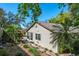 The side yard of this home features mature trees and lush landscaping on a sunny day at 275 S Highland Ave, Tarpon Springs, FL 34689