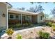 Charming home featuring a covered front porch with natural light, updated windows, and tidy landscaping at 275 S Highland Ave, Tarpon Springs, FL 34689