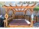 Outdoor hot tub with a wooden pergola featuring a built-in bar, decorative fish, and private fencing at 275 S Highland Ave, Tarpon Springs, FL 34689