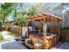 Backyard hot tub with a wooden pergola offers a relaxing outdoor oasis with a built in bar and privacy fence at 275 S Highland Ave, Tarpon Springs, FL 34689