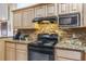 A kitchen with granite countertops, stone backsplash, and black appliances at 275 S Highland Ave, Tarpon Springs, FL 34689