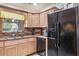 Kitchen featuring granite countertops, stainless steel sink, wooden cabinets, and a black refrigerator at 275 S Highland Ave, Tarpon Springs, FL 34689